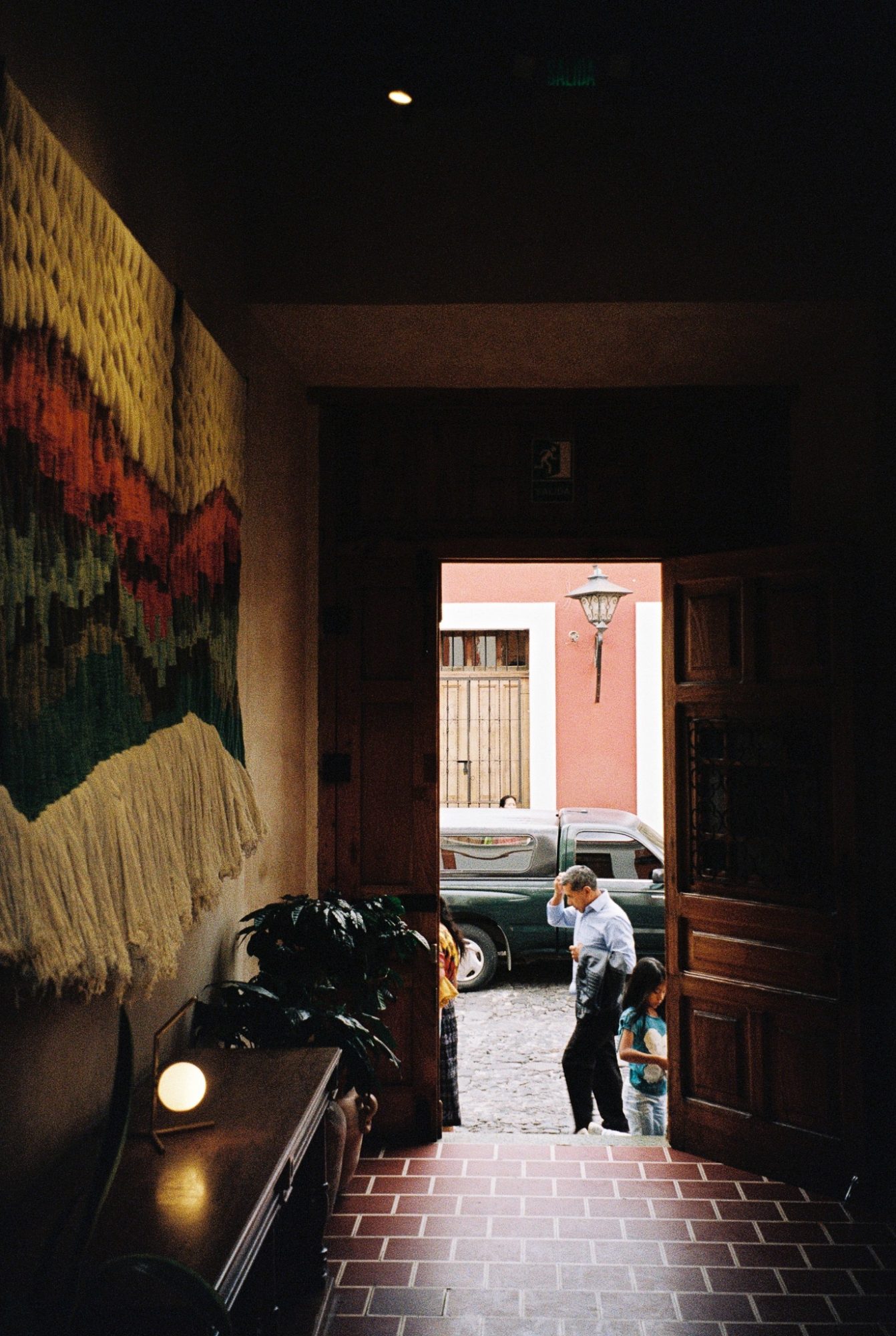 A doorway onto the street, with a woven hanging