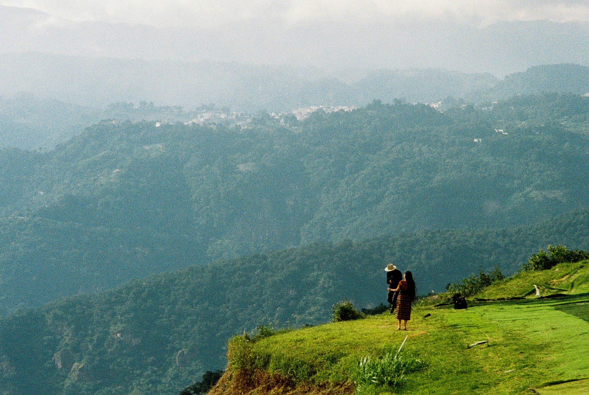 Two people on a ridge above the valley